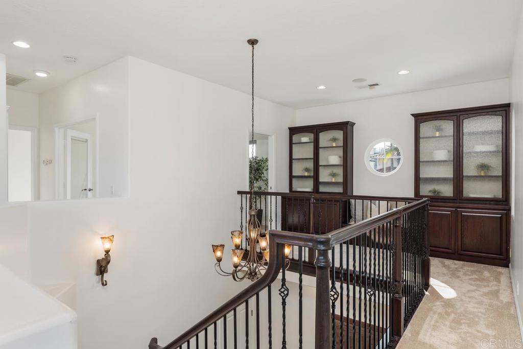 6456 Franciscan Road Carlsbad, CA 92011 - Photo 25 of 43 a view of a hallway with wooden floor and stairs
