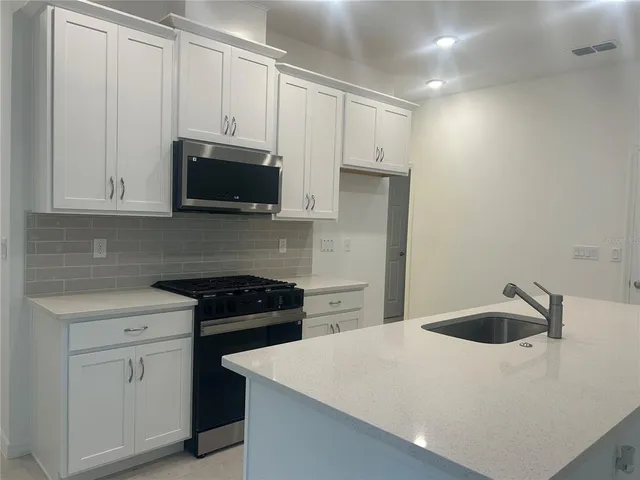 a kitchen with white cabinets and white appliances