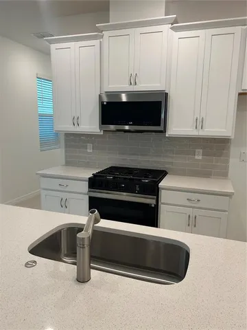 a kitchen with granite countertop a stove and a sink