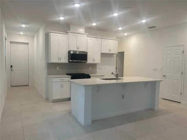 a kitchen with kitchen island cabinets and a sink