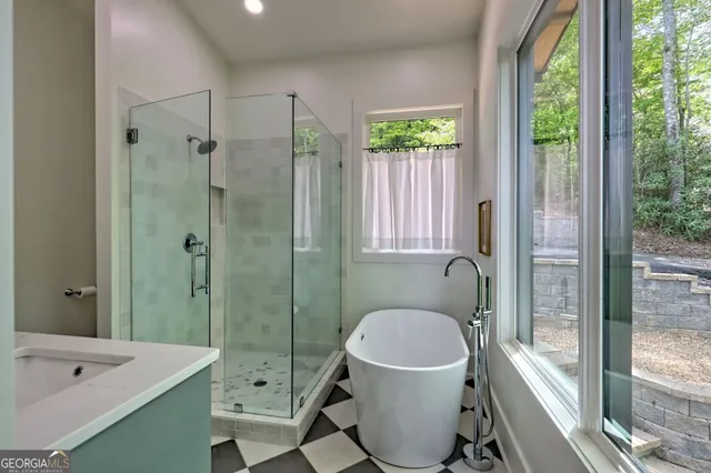 a bathroom with a granite countertop sink a mirror and shower