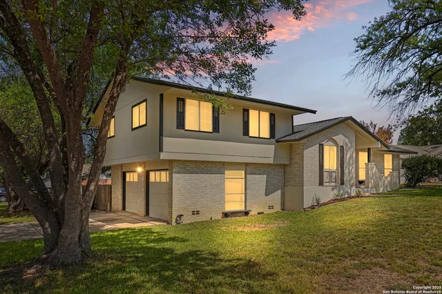 a front view of a house with yard and green space