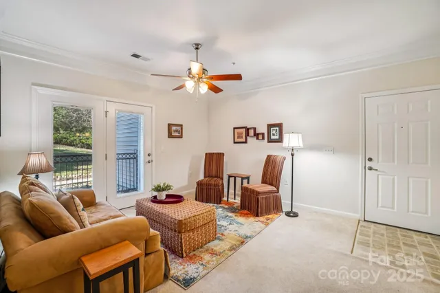 a living room with furniture a ceiling fan and a window