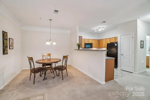 a kitchen with kitchen island a dining table chairs stainless steel appliances and cabinets