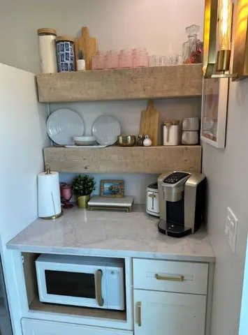 a kitchen with kitchen island granite countertop stainless steel appliances a stove refrigerator and microwave