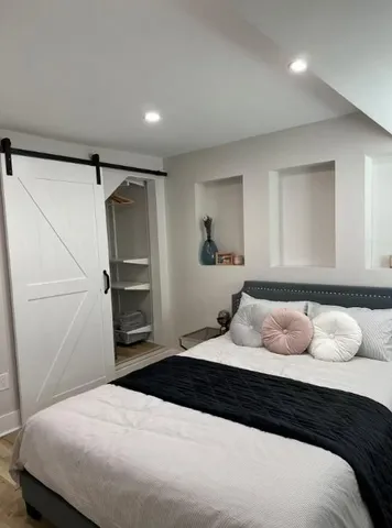 a bedroom with a bed and wooden floor