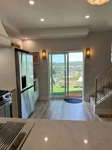 a view of a kitchen with fridge and wooden floor