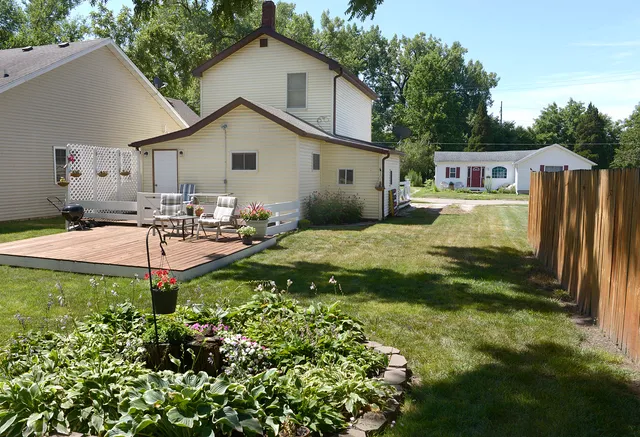 a view of a house with backyard and sitting area