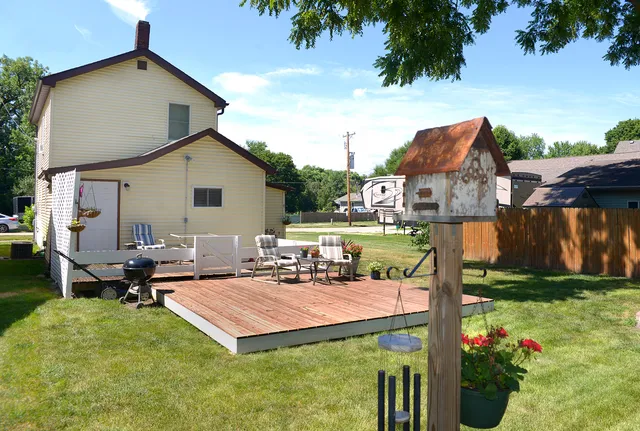 a backyard of a house with table and chairs