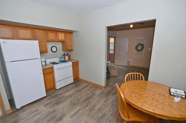 a kitchen with a refrigerator and a stove top oven