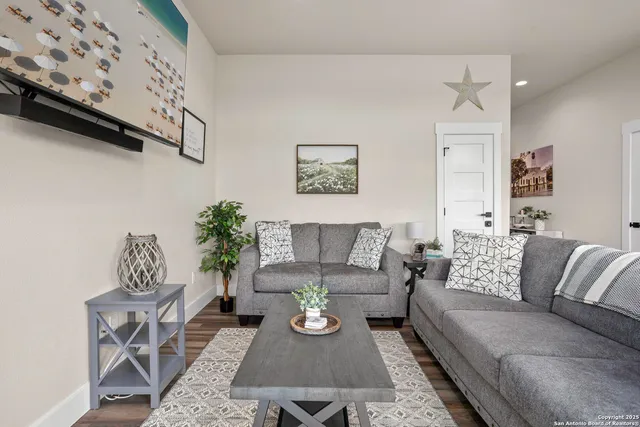 a living room with furniture a rug and a wall painting