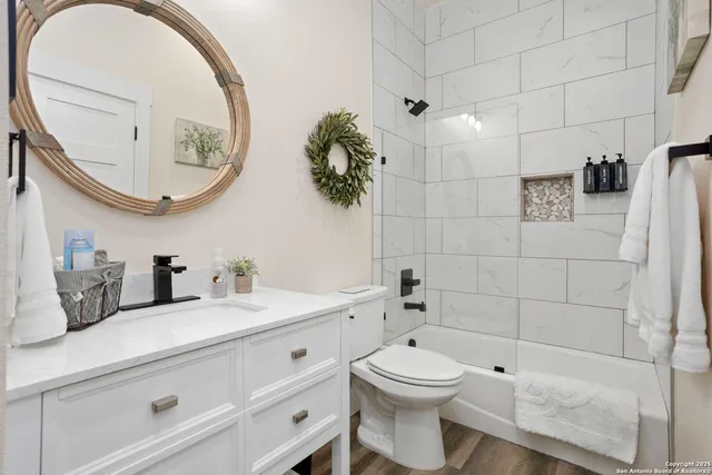 a bathroom with a granite countertop toilet sink and mirror