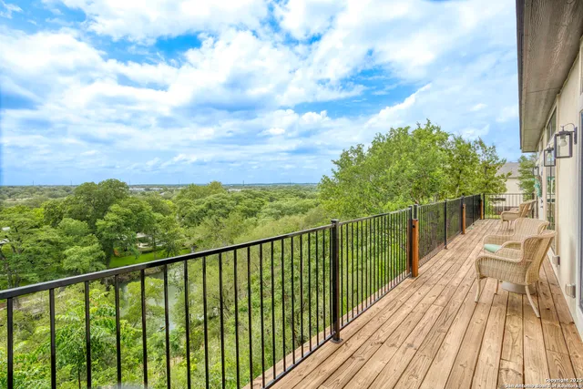 a view of balcony with wooden floor and fence