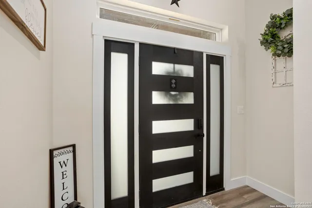 a view of a hallway with wooden floor and entryway
