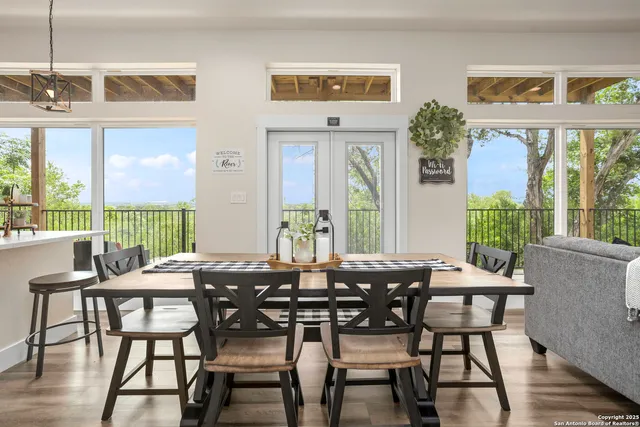 a view of a dining room with furniture large windows and wooden floor
