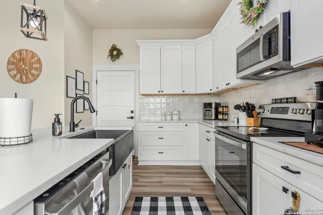a kitchen with granite countertop a sink a stove and cabinets
