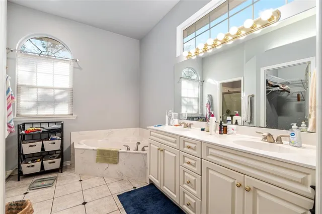 a bathroom with double vanity and a mirror