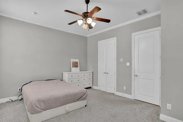 a bedroom with a bed and a ceiling fan
