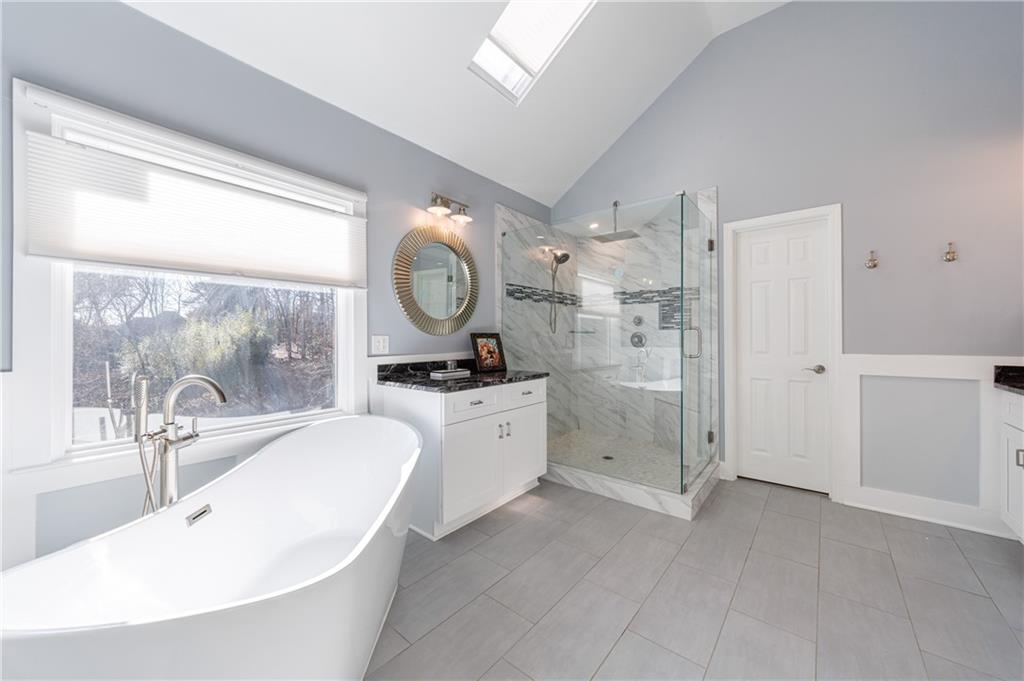 6010 Masters Club Drive Suwanee, GA 30024 - Photo 25 of 65 a large bathroom with a double vanity sink a mirror and a large mirror next to a window