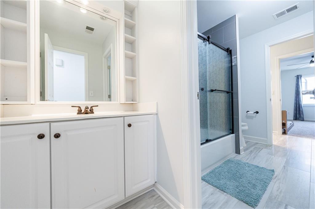 6010 Masters Club Drive Suwanee, GA 30024 - Photo 35 of 65 a bathroom with a shower sink and mirror