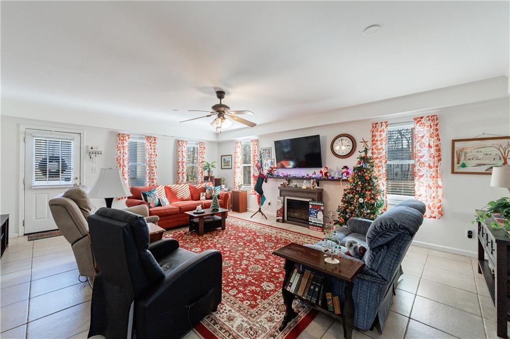 6010 Masters Club Drive Suwanee, GA 30024 - Photo 40 of 65 a living room with furniture a fireplace and a flat screen tv