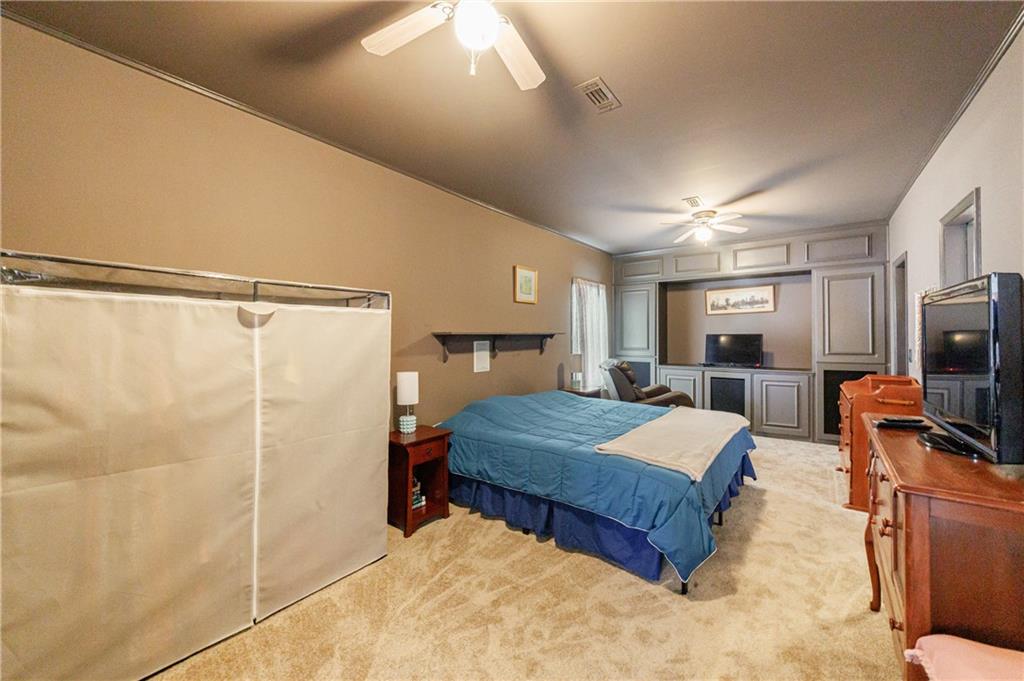 6010 Masters Club Drive Suwanee, GA 30024 - Photo 41 of 65 a bedroom with a bed and a flat tv screen on the dresser