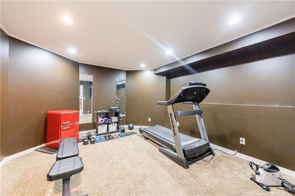 6010 Masters Club Drive Suwanee, GA 30024 - Photo 46 of 65 a room with gym equipment and a view of living room
