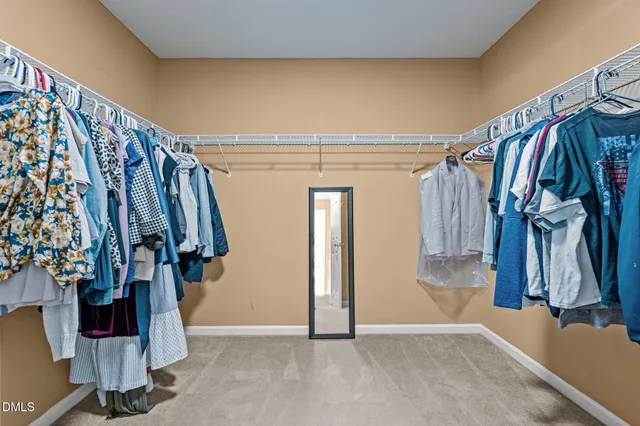 a view of walk in closet with clothes and shoes