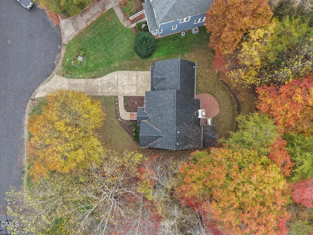 an aerial view of a house with a yard and mountain view in back