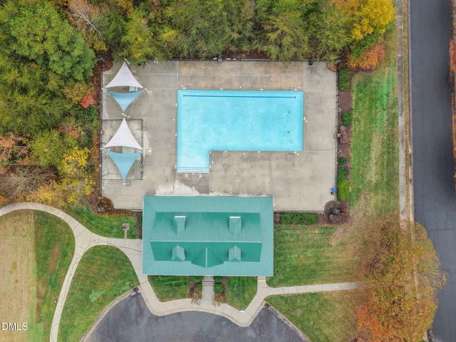 a view of a swimming pool with a yard and plants