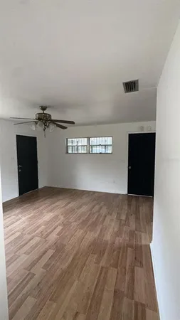 a view of empty room with wooden floor