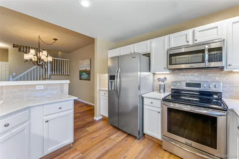 a kitchen with granite countertop wooden cabinets and stainless steel appliances