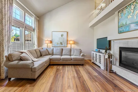 a living room with furniture a flat screen tv and a fireplace