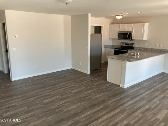 a kitchen with granite countertop a refrigerator and a stove top oven