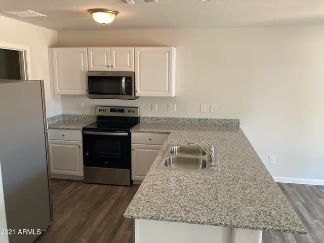a kitchen with granite countertop a sink and a stove top oven