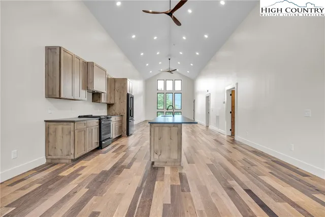 a kitchen with granite countertop a refrigerator stove top oven and sink