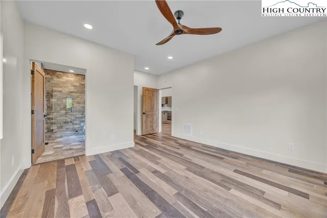 an empty room with a ceiling fan and windows