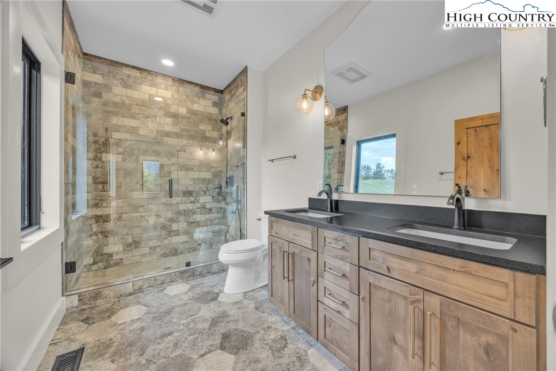Range View Drive, Unit TBD Jefferson, NC 28640 - Photo 32 of 46 a bathroom with a granite countertop sink a toilet a mirror and shower