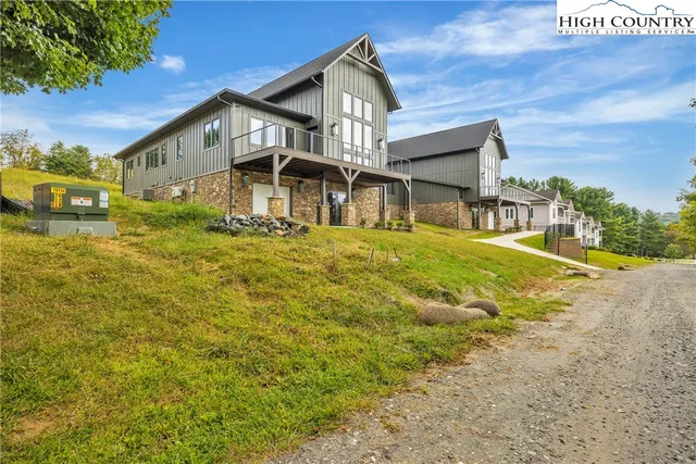 a large kitchen with stainless steel appliances granite countertop a refrigerator a sink dishwasher a stove and a dining table with wooden floor