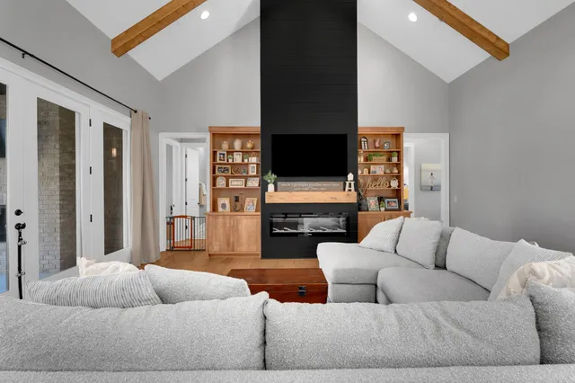 a kitchen with stainless steel appliances granite countertop a refrigerator a sink dishwasher a stove and a dining table with wooden floor