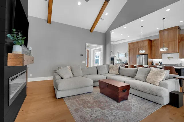 a kitchen with stainless steel appliances granite countertop a kitchen island a table chairs and a refrigerator