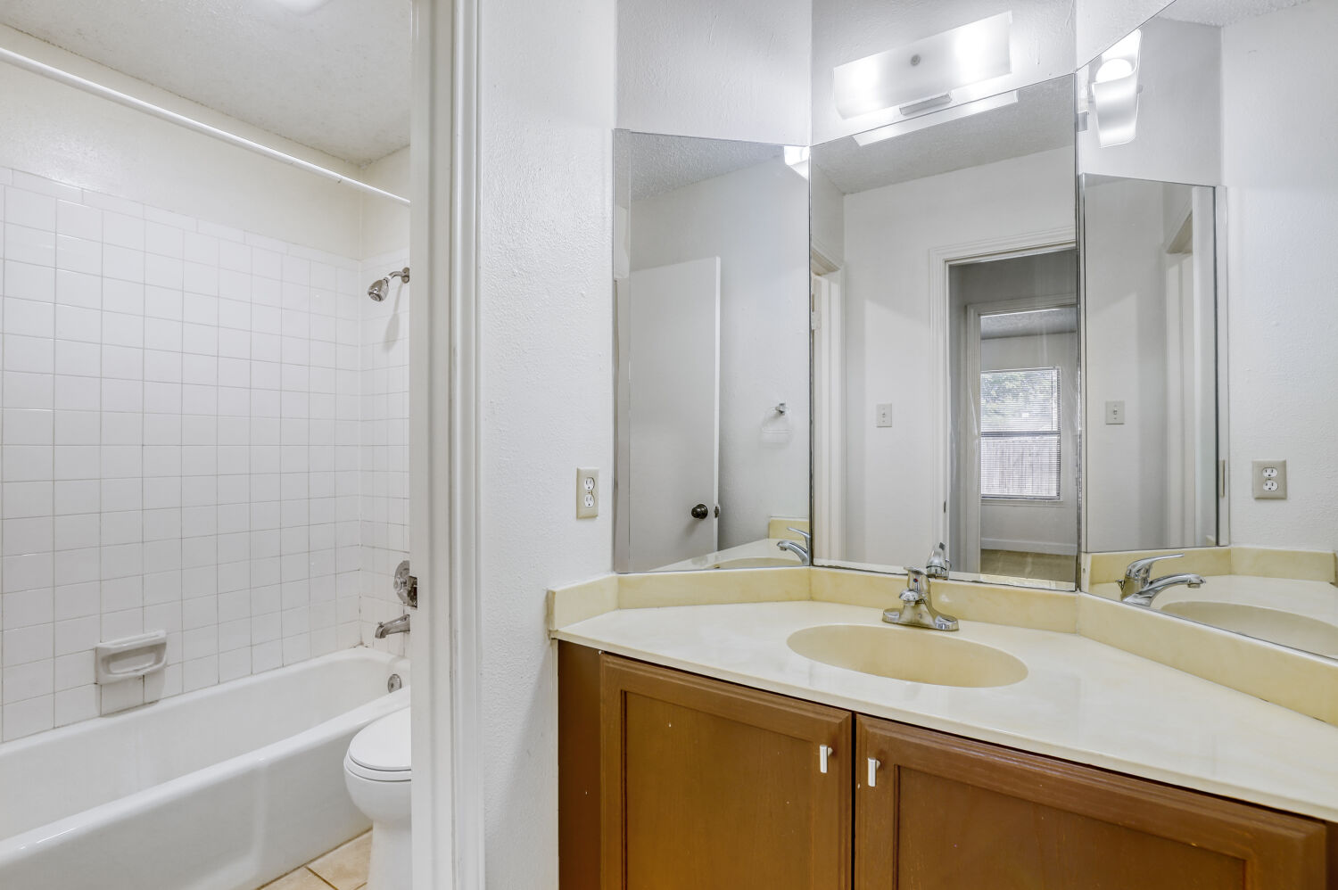 7806 Chimayo Cove, Unit B Austin, TX 78729 - Photo 9 of 11 a bathroom with a granite countertop sink mirror and a bathtub