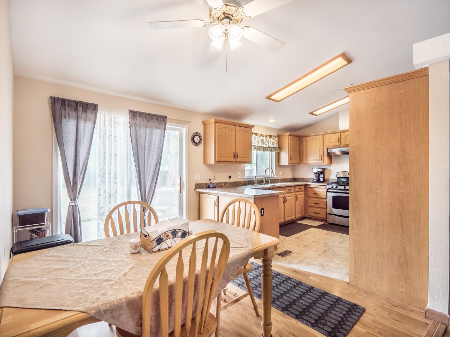 9 Dick Phelps Road Watsonville, CA 95076 - Photo 12 of 32 a kitchen with a refrigerator a sink a dining table and chairs