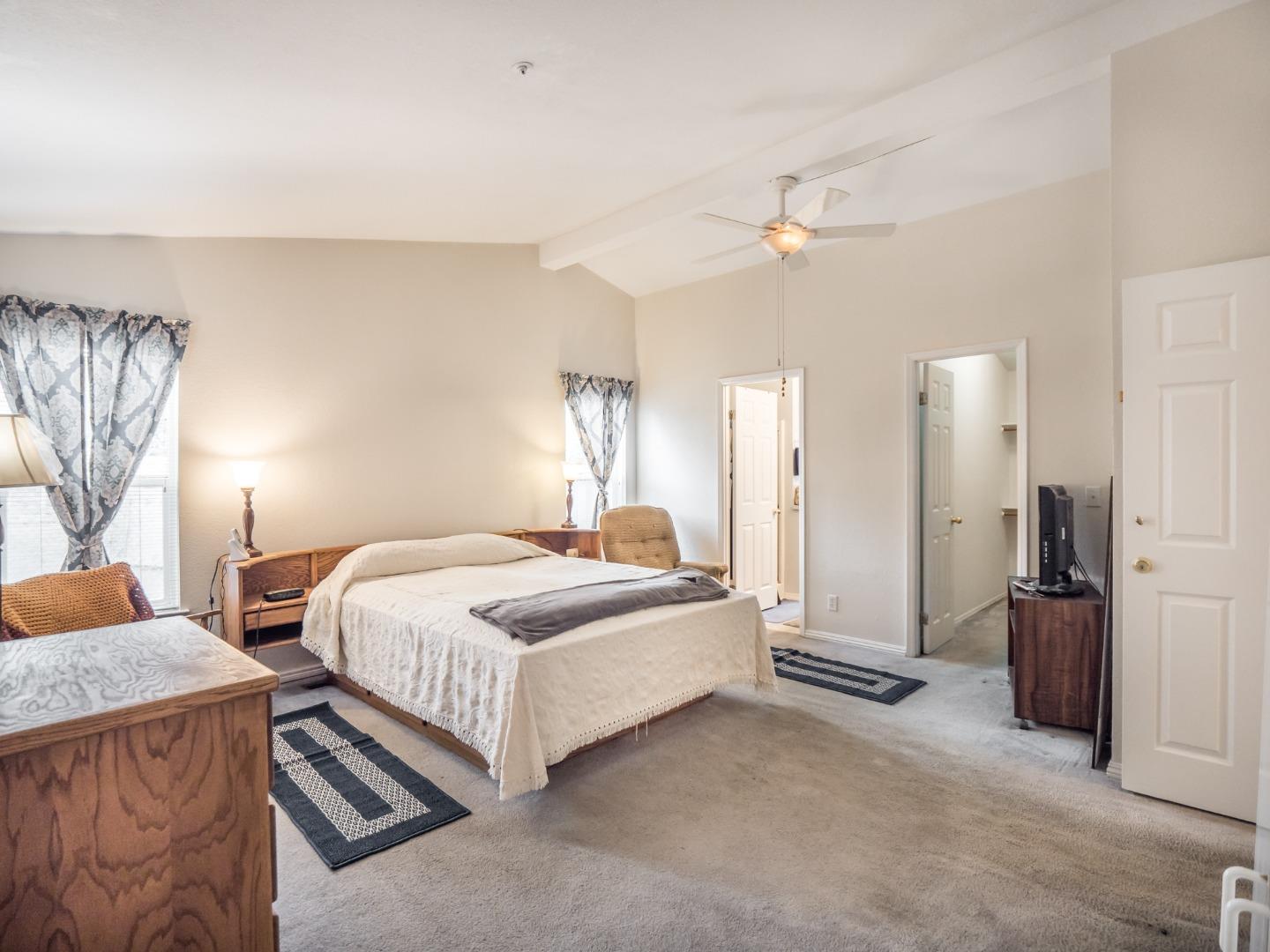 9 Dick Phelps Road Watsonville, CA 95076 - Photo 24 of 32 a spacious bedroom with a bed and a chandelier