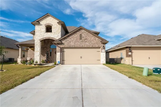 a front view of a house with a yard and garage