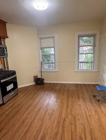 a view of a livingroom with wooden floor and a fireplace