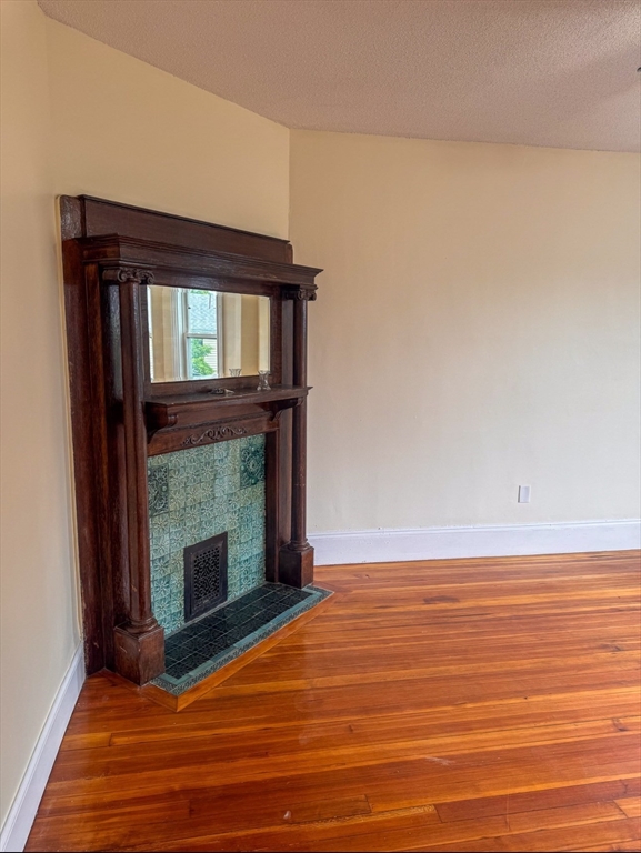 35 Hollander Street, Unit 2 Boston, MA 02121 - Photo 4 of 17 a view of an empty room with wooden floor fireplace and a window