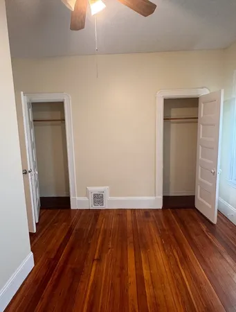 an empty room with wooden floor and a window