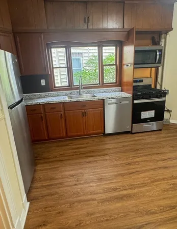 a view of a kitchen with wooden floor and electronic appliances