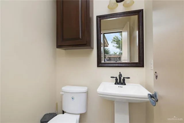 a bathroom with a toilet a sink and mirror